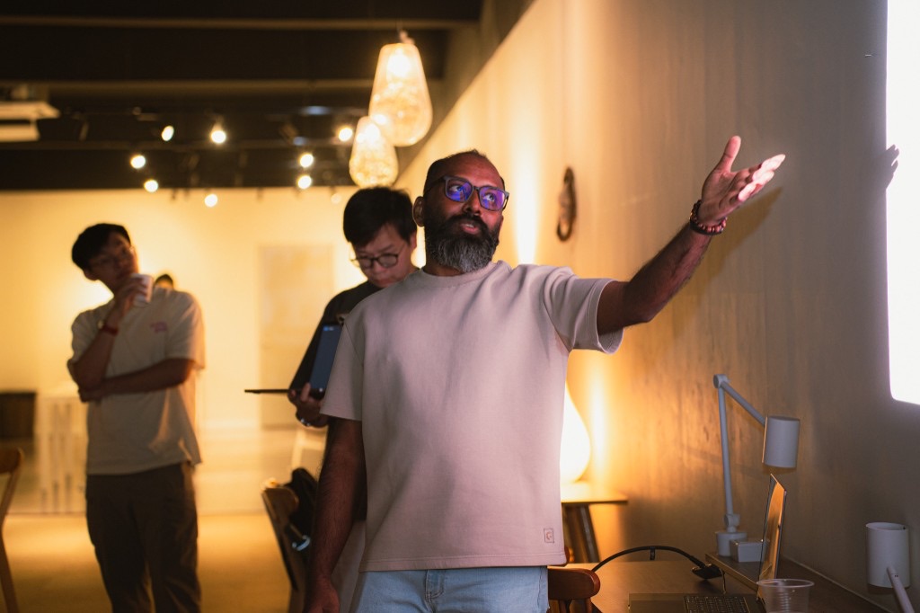 Bearded presenter gesturing at the projection wall
